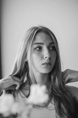 Girl with blue eyes sitting on urban cafe. woman with brown wavy hairstyle.Lifestyle concept. Portrait.Bokeh lights, blurred background, greenery.Black and white photo of a girlの写真素材