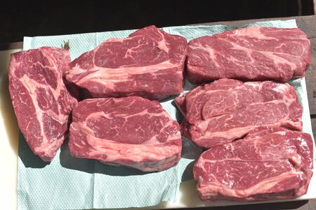 Prime raw rib-eye steak. Raw Beef Steaks.Raw beef steaks are trapped on paper to remove excess...