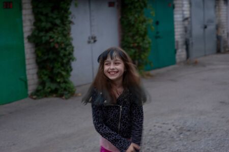 Portrait of nine year old girl. The child is walking in the fresh air. Teenager with blue strands on her hair. The girl with brown hair. A series of photos of a girl of 8 or 9 years oldの写真素材
