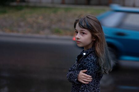 Portrait of nine year old girl. The child is walking in the fresh air. Teenager with blue strands on her hair. The girl with brown hair. A series of photos of a girl of 8 or 9 years oldの写真素材