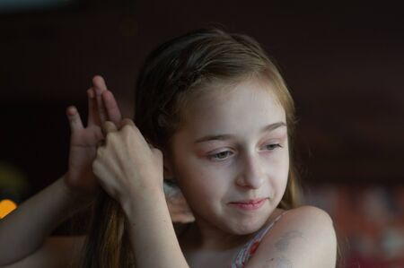 Portrait of a 9 years old female child, portrait concept of a child. Close-up face of beautiful girl 8-9 years old. Concept child teenager. A girl with long blond hair. Girl 9 years old in a cafeの写真素材