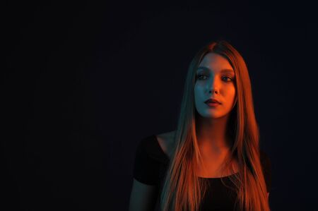 Beautiful, glamorous, girl, model in a photo studio with color filters. Portrait, beauty, style. Girl in a photo studio with a yellow filter. A girl of 18 years old with blond hair and beautiful eyes.の写真素材