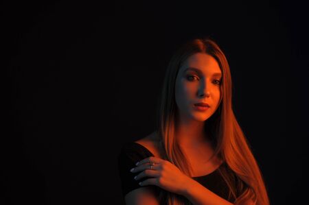Beautiful, glamorous, girl, model in a photo studio with color filters. Portrait, beauty, style. Girl in a photo studio with a yellow filter. A girl of 18 years old with blond hair and beautiful eyes.の写真素材