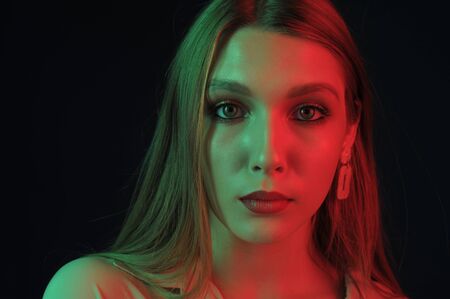 Beautiful, glamorous, girl, model in a photo studio with color filters. Portrait, beauty, style. Girl in a photo studio with a yellow filter. A girl of 18 years old with blond hair and beautiful eyes.の写真素材