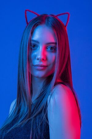 High Fashion model woman in colorful bright lights posing in studio, portrait of beautiful sexy girl with trendy make-up. Art design, colorful make up. Over colourful vivid background. Cat-girlの写真素材