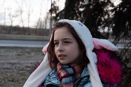 cute little girl in hood with ears. girl in a hat bunny street. Beautiful young cute woman in blue...