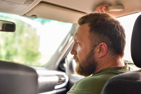 Attractive man in good car. Man with a beard in a car. A man with a beard in a car is not driving....