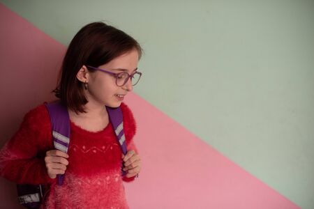9 years old schoolgirl with glasses in school. Seriously disposed student. Modern children. A girl of 9 years old. 4th grade school. Portrait of a girl of 9 years old. Schoolgirl haircut and glassesの写真素材
