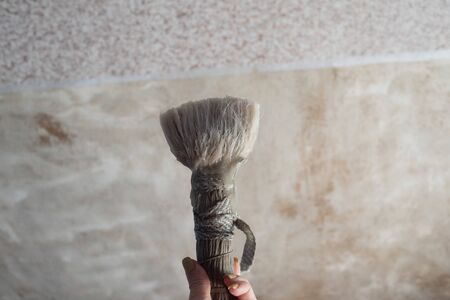 Photo of the apartment during the repair. Adhesive brush for wallpapering. repairs. Part of the wallpaper is stripped, part pasted. Wallpapering part of the wall in glue. Repair brushの写真素材