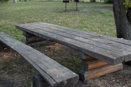 Garden wooden bench isolated in the green meadows. Wooden table and bench on the nature. Nature,...