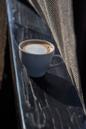 Coffee selective focus. White cup with cappuccino on the nature. White cup with cappuccino, coffee, morning, cheerfulness.の写真素材