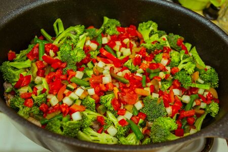 Fried piece of turkey meat with onions and spices. Pieces of turkey carrot onion. The process of cooking vegetable stew with turkey. Steamed vegetables with turkey broccoli onion carrot pepper tomatoの写真素材