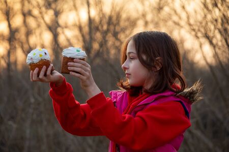 A happy little girl looking at an eastern cake. Easter concept. Traditional homemade easter and...