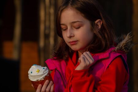 A happy little girl looking at an eastern cake. Easter concept. Traditional homemade easter and...