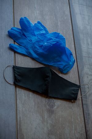 A protective half mask is lying on the table next to a pair of disposable gloves. Protective items to help fight the virus. Mask and gloves crown virusの写真素材
