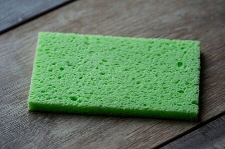 Cellulose sponge kitchen objects on the wood texture background. Cellulose napkin on the table.の写真素材