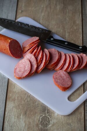sliced sausages on chopping board. Sliced sausage on the board.
