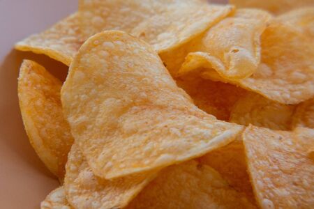 closeup of a bowl with potato chips. Potato chips on a plate. Food photography. Chips macro photo....