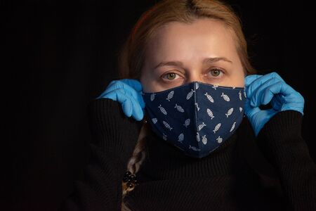 Woman in a protective mask. Young woman wearing home made hygienic face medical mask to prevent...