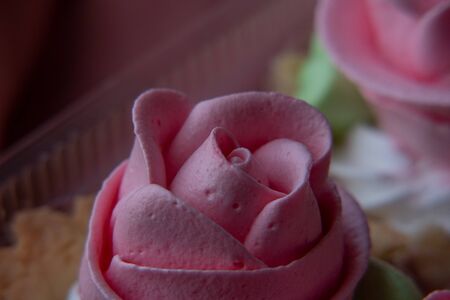 Cake Basket Rose. Food Photography, Dessert, Macro Photography. From above closeup of freshly baked cupcakes filled with berry ganache being decorated with pink buttercream frosting from pastry bagの写真素材