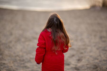 Sandy walking path on the beach on the seafront in the evening sun.At the end of the river, a little...
