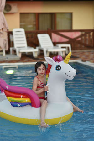 Girl swims in the pool Girl swims in the pool. Real adorable girl relaxing in swimming pool, summer vacation conceptの写真素材