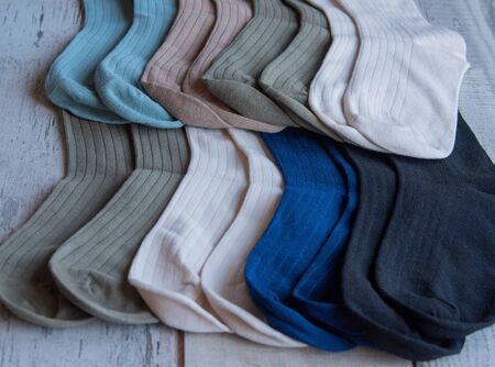 Socks of fine jersey. View from above. Many socks on a wooden background. Socks of different colors...