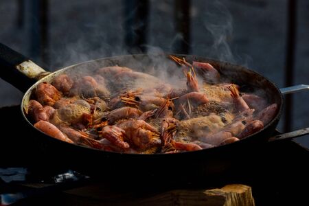 shrimp. Shrimps are cooked in a pan over a fire. Bonfire seafood