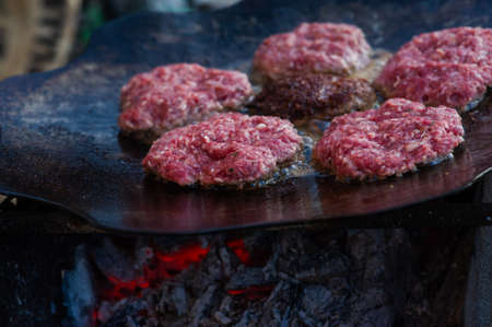 Burger Grilling on Fire. Homemade Hamburgers. Grill Meatballs. Making Hamburgers on a Grill Outdoor. Barbecue Grill Party. Meat Over Coals on Barbecue.Summer grilling.の写真素材