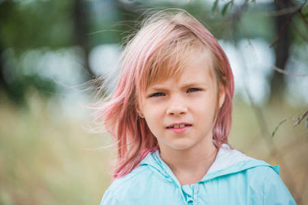 cute child girl portrait . Outdoor portrait of cute little girl in summer day. Portrait of a little girl with pink hair. Child 6-7 years oldの写真素材