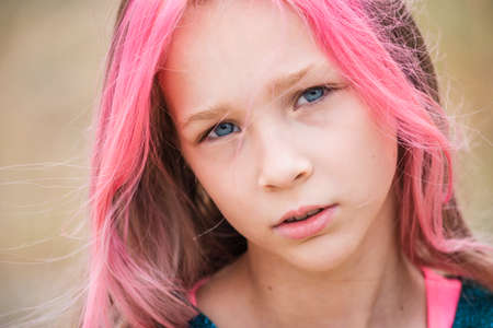 cute child girl portrait . Outdoor portrait of cute little girl in summer day. Portrait of a little girl with pink hair. Child 9-10 years old. Teenagerの写真素材