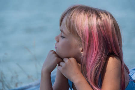 cute child girl portrait . Outdoor portrait of cute little girl in summer day. Portrait of a little girl with pink hair. Child 7-8 years old. Teenagerの写真素材
