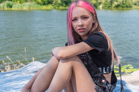 cute child girl portrait . Outdoor portrait of cute little girl in summer day. Portrait of a little girl with pink hair. Child 9-10 years old. Teenagerの写真素材