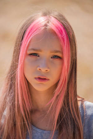 cute child girl portrait . Outdoor portrait of cute little girl in summer day. Portrait of a little girl with pink hair. Child 9-10 years old. Teenagerの写真素材