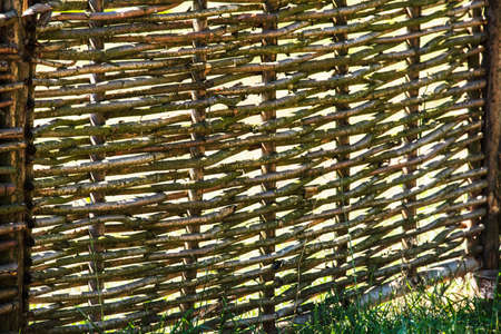 Fence wicker from the vine, texture, background. Wicker vine fence. woven vines texture embossed background. Organic woven willow wicker fence panel suitable for crafts, picnic or gardening backgroundの写真素材
