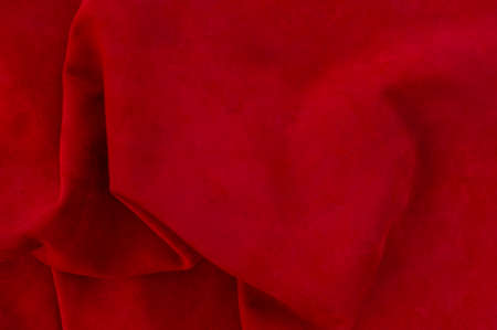 Red matte background of suede fabric, closeup. Velvet texture of seamless wine leather. Felt material macro. Red textureの写真素材