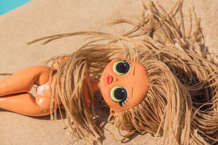 Baby doll on tropical beach with calm sea. Doll on the beach