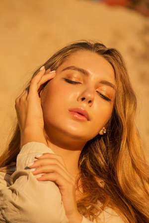 Tenderness, girl, long hair. pleasure concept. Girl on the background of sands and sky. Girl in a...