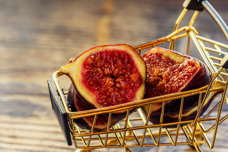 Fresh figs . Beautiful blue violet figs. Figs in grocery cart on wood background. Healthy food,...
