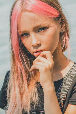 Portrait of a little girl. Beautiful girl posing. Teenager, pink hairs. Adolescence concept. Toned...