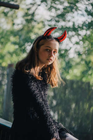 little girl in costumes for Halloween celebration. Halloween party, photo of Halloween characters. Autumn teenager portraitの写真素材