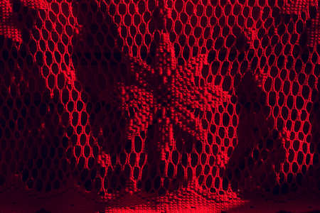 Red knitted fabric. Red fabric mesh in a flower. Red textureの写真素材