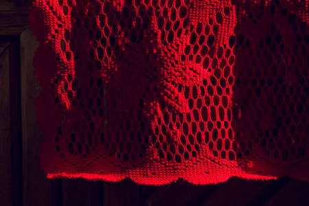 Red knitted fabric. Red fabric mesh in a flower. Red textureの写真素材