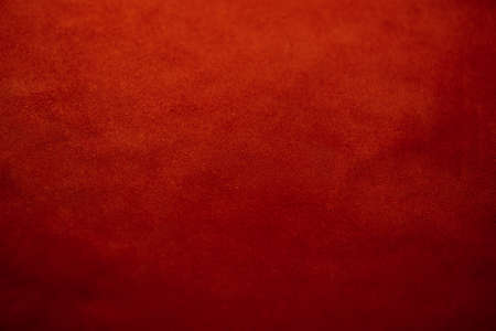 Red matte background of suede fabric, closeup. Velvet texture of seamless leather. Felt material macro. Red suede texture. Fabric, leather, material for designers.の写真素材