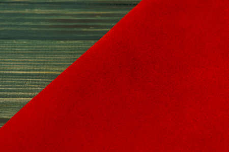 Red matte background of suede fabric, closeup. Velvet texture of seamless leather. Felt material...