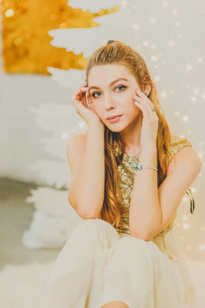 Christmas, winter holidays concept. Beautiful charming woman in evening dress posing in luxurious...
