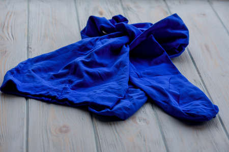 Blue tights on wood background. Blue tights as a female element of clothing. Clothes, fabric