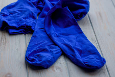 Blue tights on wood background. Blue tights as a female element of clothing. Clothes, fabricの写真素材