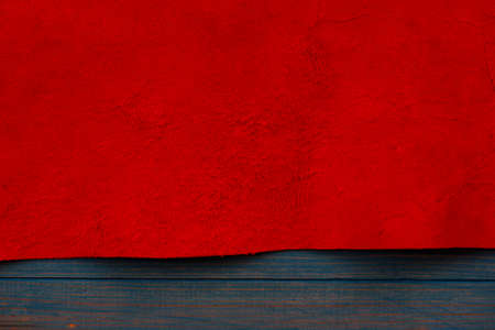 Red matte background of suede fabric, closeup. Velvet texture of seamless leather. Felt material...
