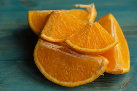 Organic orange fruit. Slices on wooden background. Orange slices on wood background. Fresh half cut oranges on wooden blue tableの写真素材